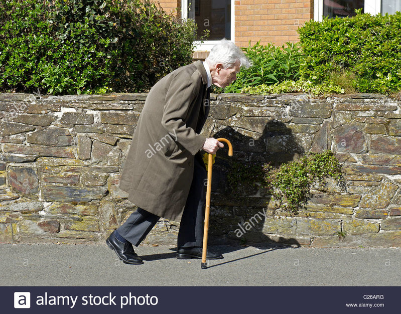 an-old-man-using-a-walking-stick-C26ARG.jpg